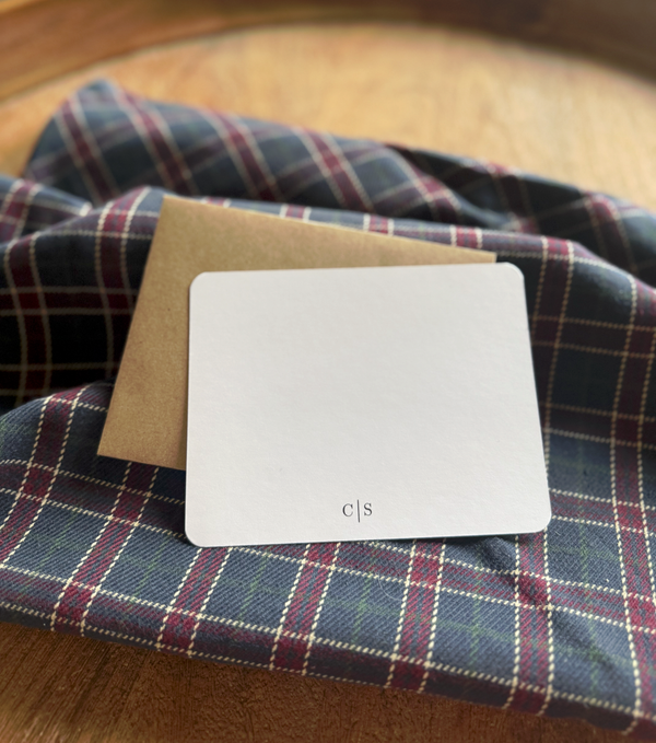 White monogrammed personalized note card on a plaid fabric background
