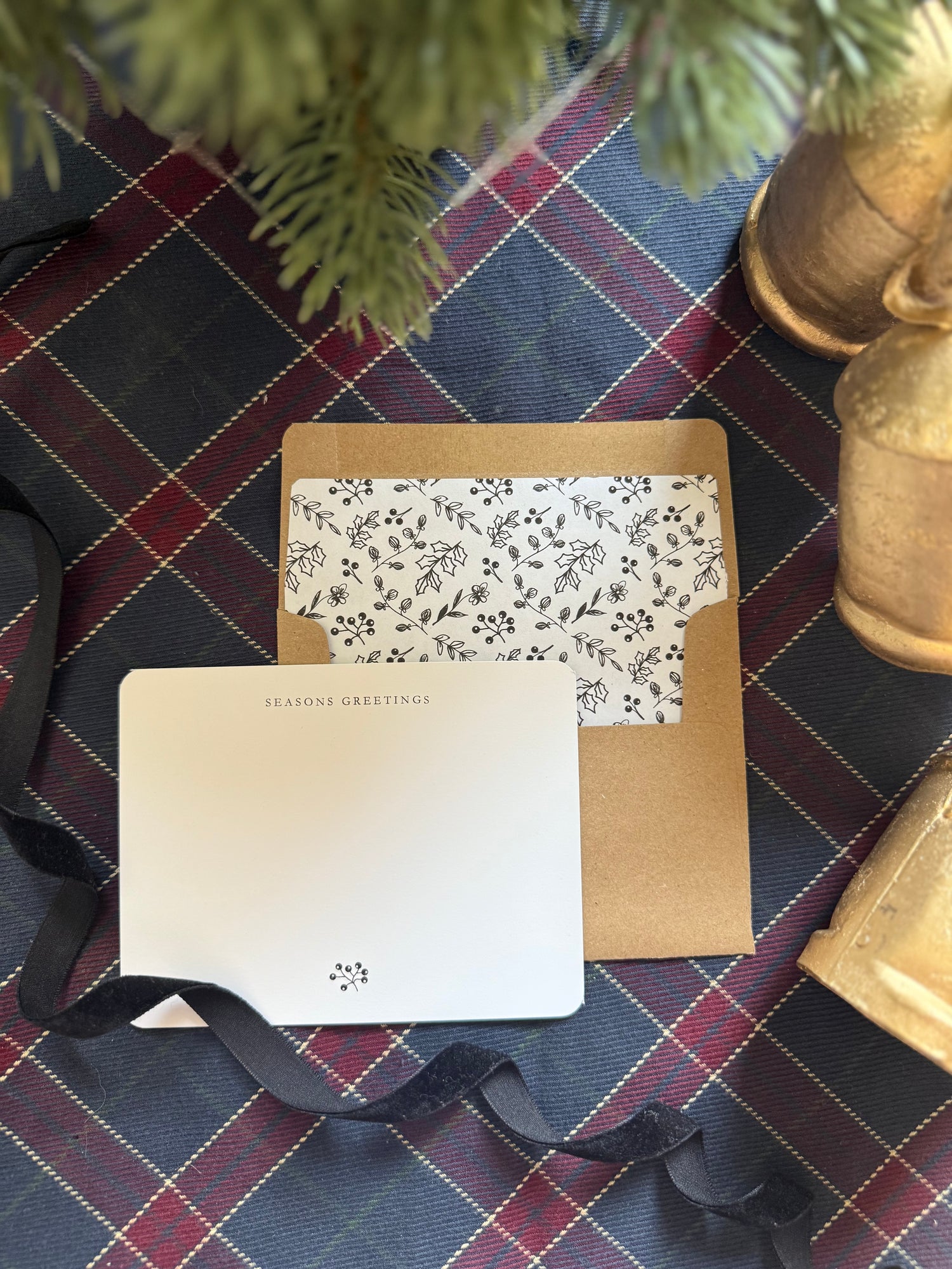 Seasons Greeting note card with envelope on a plaid fabric background